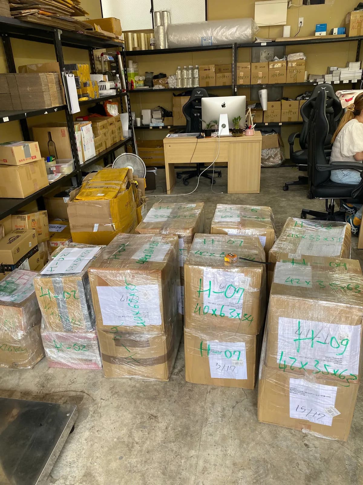 梱包を終え、行き先ごとに番号を書き入れた荷物が床に並ぶ倉庫内